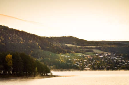 morning fog in norwegian fjord and wood landscape during autumnの写真素材