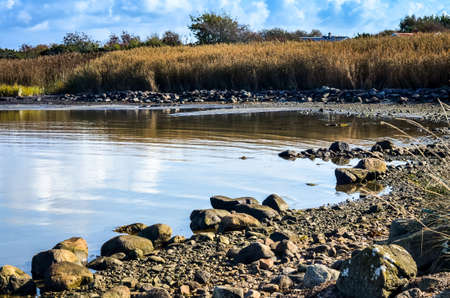 rocky sea shore with silent water in swedish autumn landscapeの写真素材