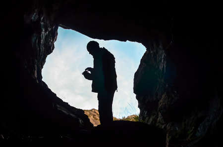 dark cave with man silhouette and waterの写真素材