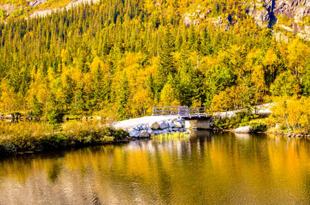 small white bridge over a fjord in autumn landscapeの写真素材