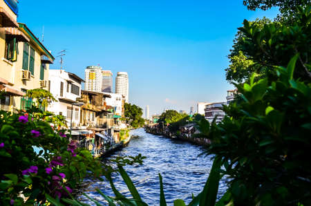 canal flowing through big city of bangkok, thailandの写真素材