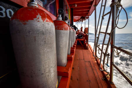 Compressed air tanks preparing for diving trip on wooden boat
