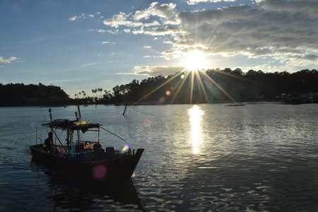 motorboat at the coast of thailand in evening sunの写真素材