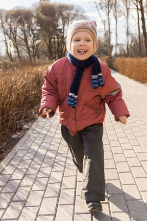 The picture shows a boy running in the parkの写真素材