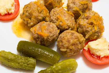The photo shows a cutlet, cucumber garnish