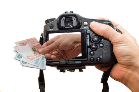 The photo depicts a camera and a hand full of moneyの写真素材