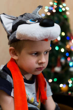 The photo depicts a sad boy at the treeの写真素材