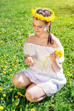 The photo shows a girl picking flowersの写真素材
