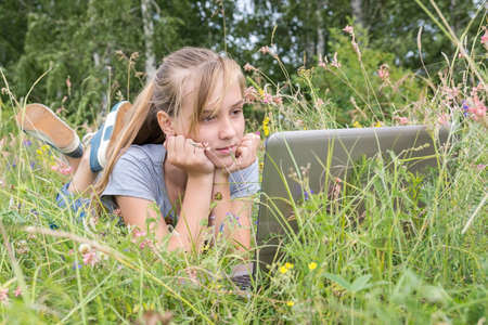 Girl on grass with laptop, summer, Russia, flowers