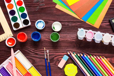 School supplies on a red background, paints and brushesの写真素材