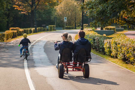 A married couple with a child on a walk in a park on bicyclesの写真素材