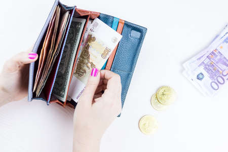 purse with money and bitcoin in hands on a white backgroundの写真素材