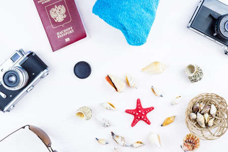 Seashells and camera on white background, passport, travelの写真素材