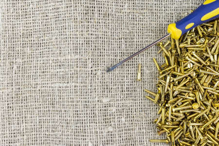screwdriver and screws on sacking, tools on sackingの写真素材