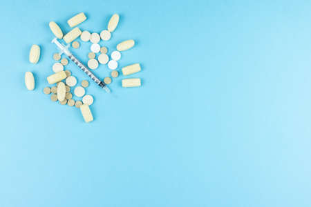 pills and a syringe on a blue background, medicinesの写真素材