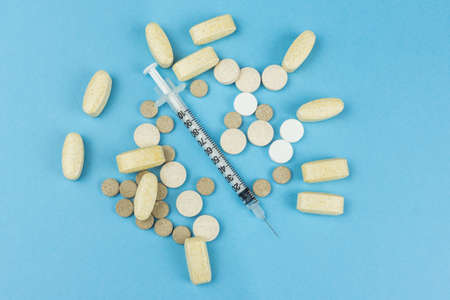 pills and a syringe on a blue background, medicinesの写真素材