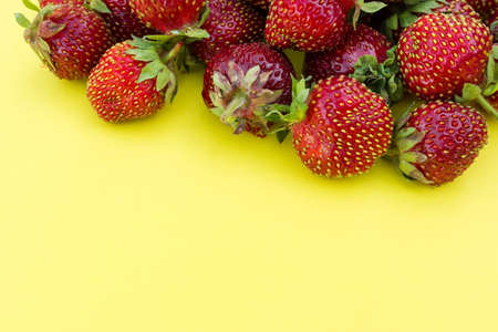 Ripe fresh strawberry on a yellow background