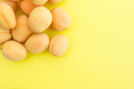 Ripe fresh apricots on a yellow backgroundの写真素材