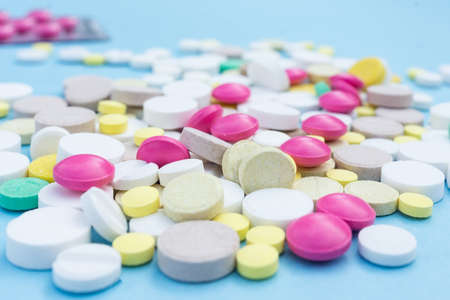 Assorted pharmaceutical medicine pills, tablets and capsules over blue backgroundの写真素材