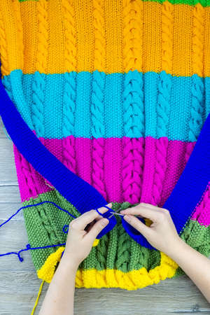 girl knits blanket knitting needles on gray background