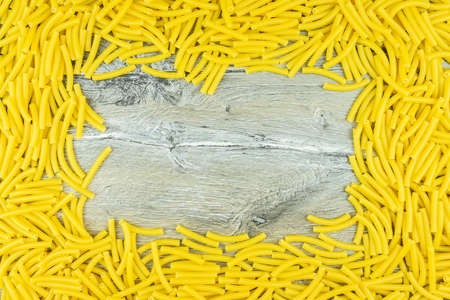 Background of scattered uncooked Italian maccheroni pasta shellsの写真素材