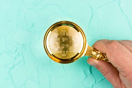 bitcoin under a magnifying glass on a green background, the growth of bitcoinの写真素材