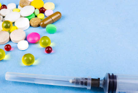 Assorted pharmaceutical medicine pills, tablets and capsules over blue backgroundの写真素材