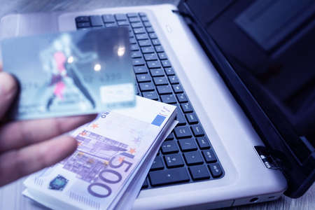 Photo businessman working with generic design notebook. Online payments, banking, hands keyboard. Businessman holding smartphone in hand and credit cardの写真素材