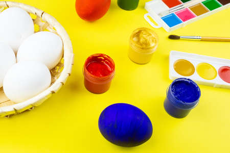 White eggs, paints, tassels, preparation for coloring for Easter.