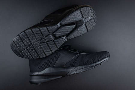 black sneaker with orange insert, mesh fabric, on a black background, running and fitness sneakers on black backgroundの写真素材