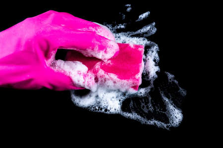 A gloved hand wipes foam and dirt with a washcloth. Cleaning