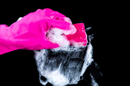 A gloved hand wipes foam and dirt with a washcloth. Cleaningの写真素材