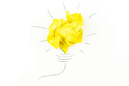 creative concept "idea", a new idea. Painted light bulb with a crumpled paper yellow ball.の写真素材