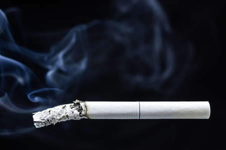 Smoke and cigarette on black background, cigarette smoke on black textureの写真素材