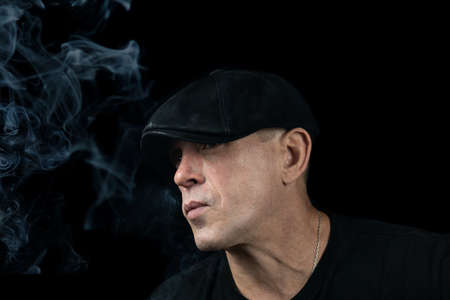 A handsome young man with a cigarette in the cloud of smoke