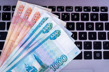 A pack of Russian rubles lies on the laptop keyboard. Top view.の写真素材