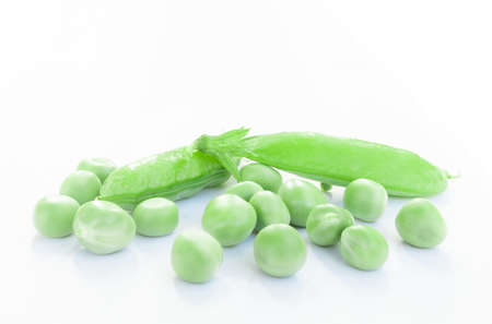 green pea pods with open pod and peas on white backgroundの写真素材