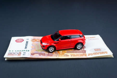 The red car is on the money, a Toy car on money