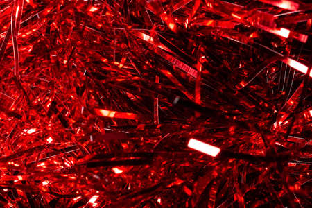 Christmas red background, texture with abstract christmas decorations. Concept background for New Year and Christmas holidays with sparkles, needles and tinsel. Bright luminous pattern with copyspaceの写真素材