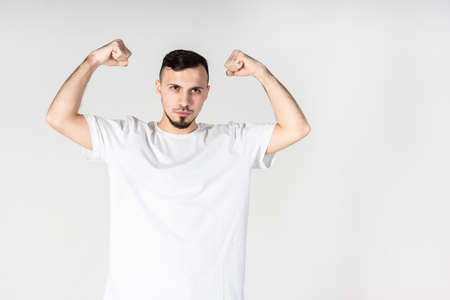 Smiling man in empty t-shirt, white grunge wall backgroundの写真素材