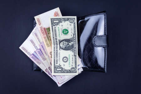 A man is holding an open wallet with money in his hands. Hands take out bills from his wallet. The concept of rejection of paper money, inflation, financial crisis.の写真素材