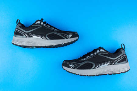 black running shoes on a blue backgroundの写真素材