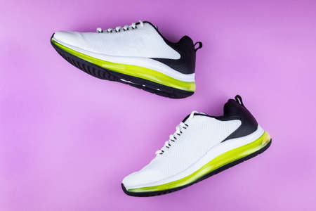 black and white running shoes on a pink backgroundの写真素材