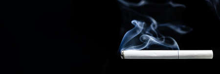 Smoke and cigarette on black background, cigarette smoke on black texture. Photo banner, space for textの写真素材