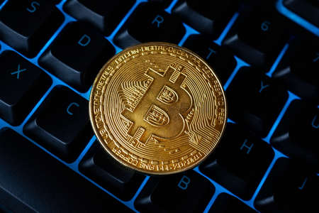 Bitcoin on compuer keyboard in background, symbol of electronic virtual money and mining...