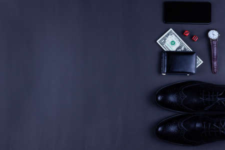 dice, men's shoes and wallet with a dollar on a black background, success of the casino gameの写真素材