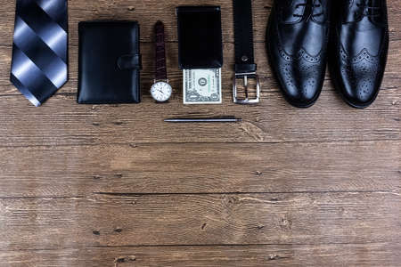 Business flat lay background with a copy space. Male shoes, wrist watch, wallet, belt and a necktie...
