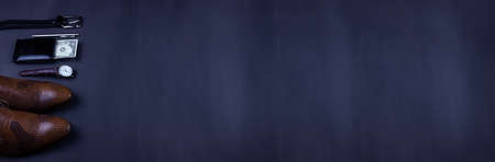 Business flat lay background with a copy space. Male shoes, wrist watch wallet, belt, mobile phone and a necktie on black background.の写真素材