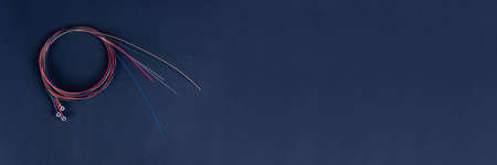 set of six coiled acoustic guitar strings randomly placed against black backgroundの写真素材