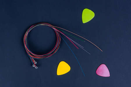 set of six coiled acoustic guitar strings randomly placed against black background